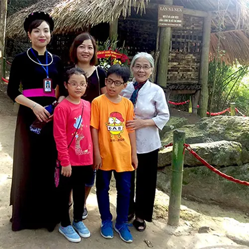 Du khách tour ATK Tân Trào Tuyên Quang chụp ảnh lưu niệm tại di tích lịch sử lán Nà Nưa