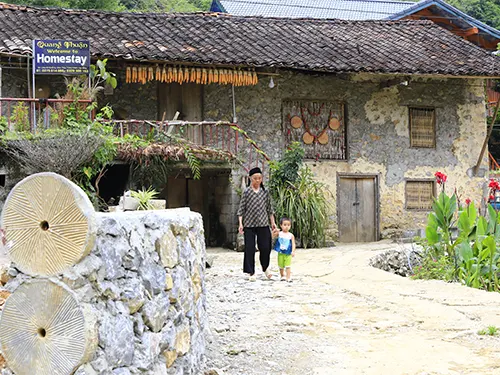 Người dân và trẻ nhỏ trước ngôi nhà sàn đá làm homestay ở làng đá Khuổi Ky, Trùng Khánh, Cao Bằng