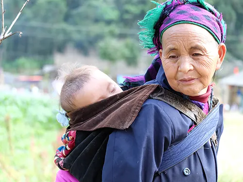 Bà cụ người Mông địu em bé ngủ trên lưng ở làng văn hóa Lũng Cẩm, Sủng Là, Hà Giang