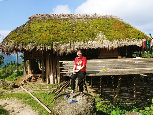Du khách nghỉ chân bên ngôi nhà mái rêu ở bản nhà rêu Hà Giang
