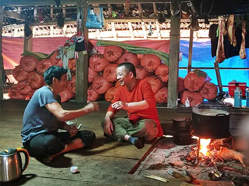 Chủ nhà người Dao rót rượu mời khách bên bếp lửa nhà sàn ở thôn Xà Phìn, Hà Giang