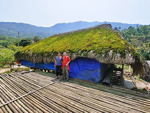 Du khách trên sàn phơi trước ngôi nhà mái rêu ở Xà Phìn