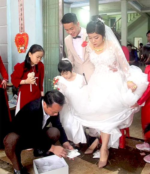 Cha hoặc chú đi giày cho cô dâu trong ngày cưới